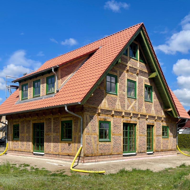 Fachwerkhaus mit rotem Satteldach und grünen Fenstern. Baustellenupdate