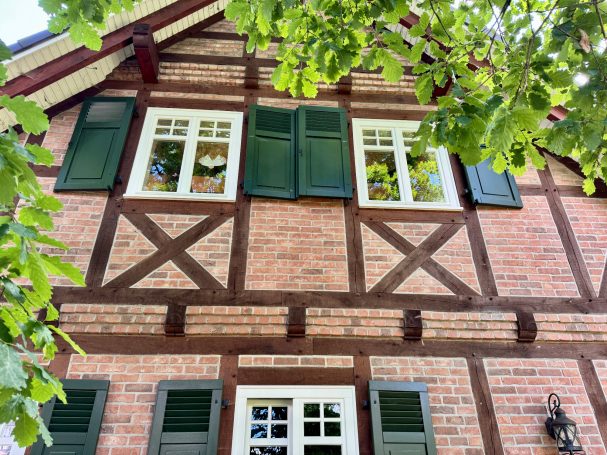 Fachwerkhaus mit braunen Holzdetails und grünen Fensterläden.