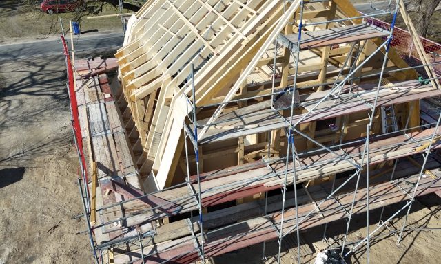 Rohbau eines Hauses mit Holzgerüst und Baugerüst.
