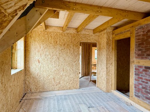 Rohbau eines Zimmers mit Holzverkleidung und offenem Raumkonzept.